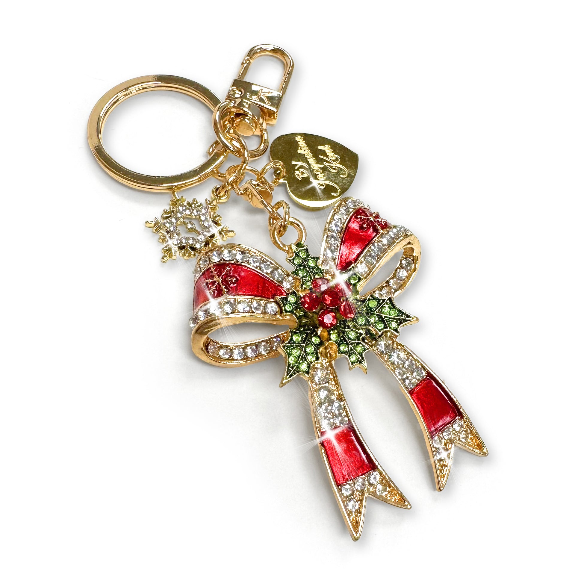Gold Christmas bow purse charm/keychain in red enamel, clear, green and red rhinestone details with a snowflake charm and gold heart shaped branded Jacqueline Kent tag
