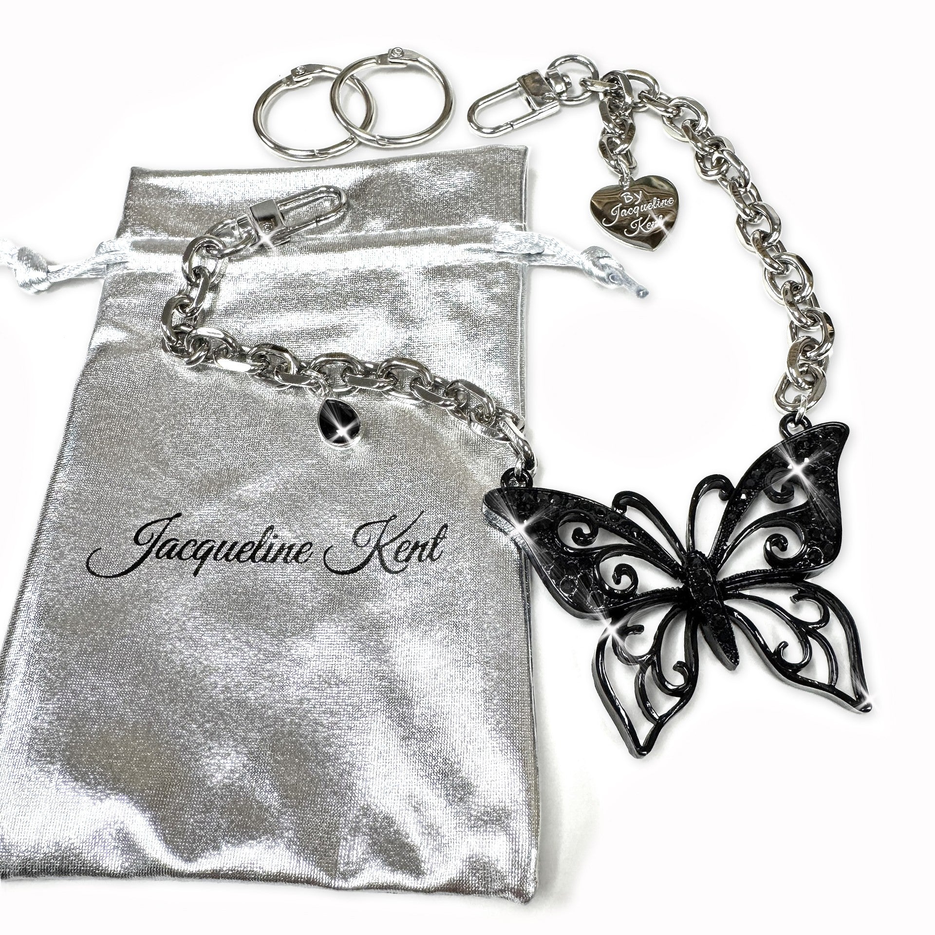 A sleek and sophisticated purse chain featuring an all-black butterfly motif. The Jacqueline Kent Charming Chain in Black Butterfly is shown with its secure clasps and lightweight chain, designed to attach effortlessly to any handbag for an instant style upgrade.