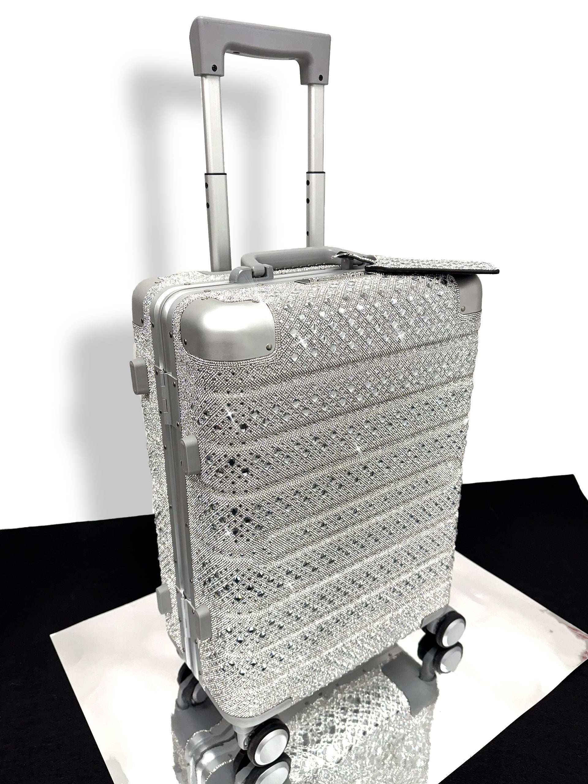Silver suitcase with a rhinestone textured pattern on a white background