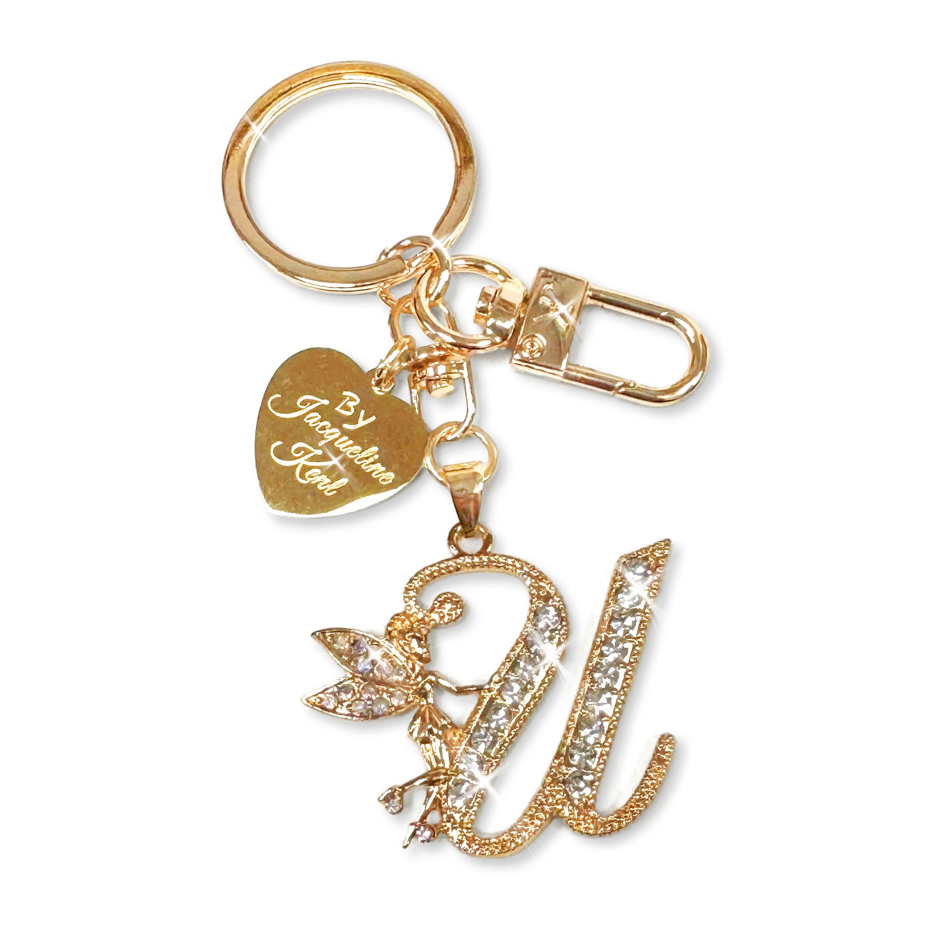 Gold and crystal embellished keychain with decorative letter 'U' and heart-shaped Jacqueline Kent branded tag on a white background
