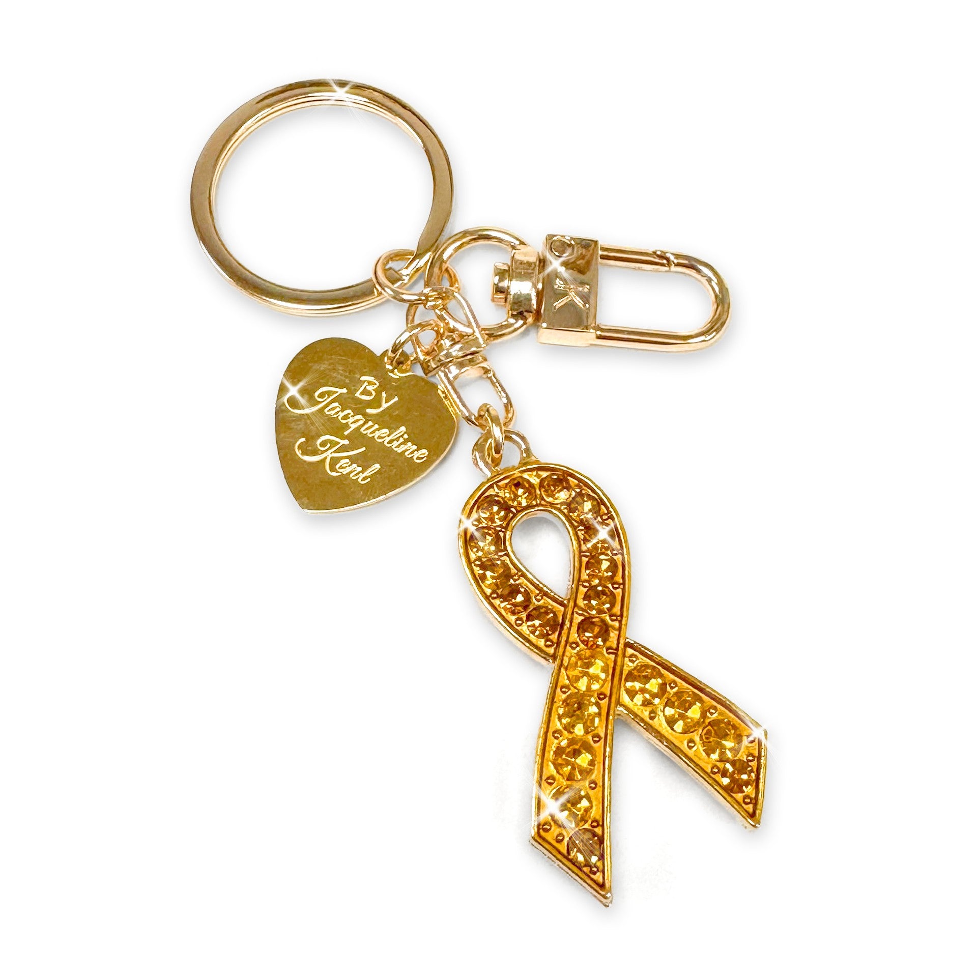 Gold purse charm/keychain with yellow rhinestone ribbon charm and heart-shaped tag on a white background