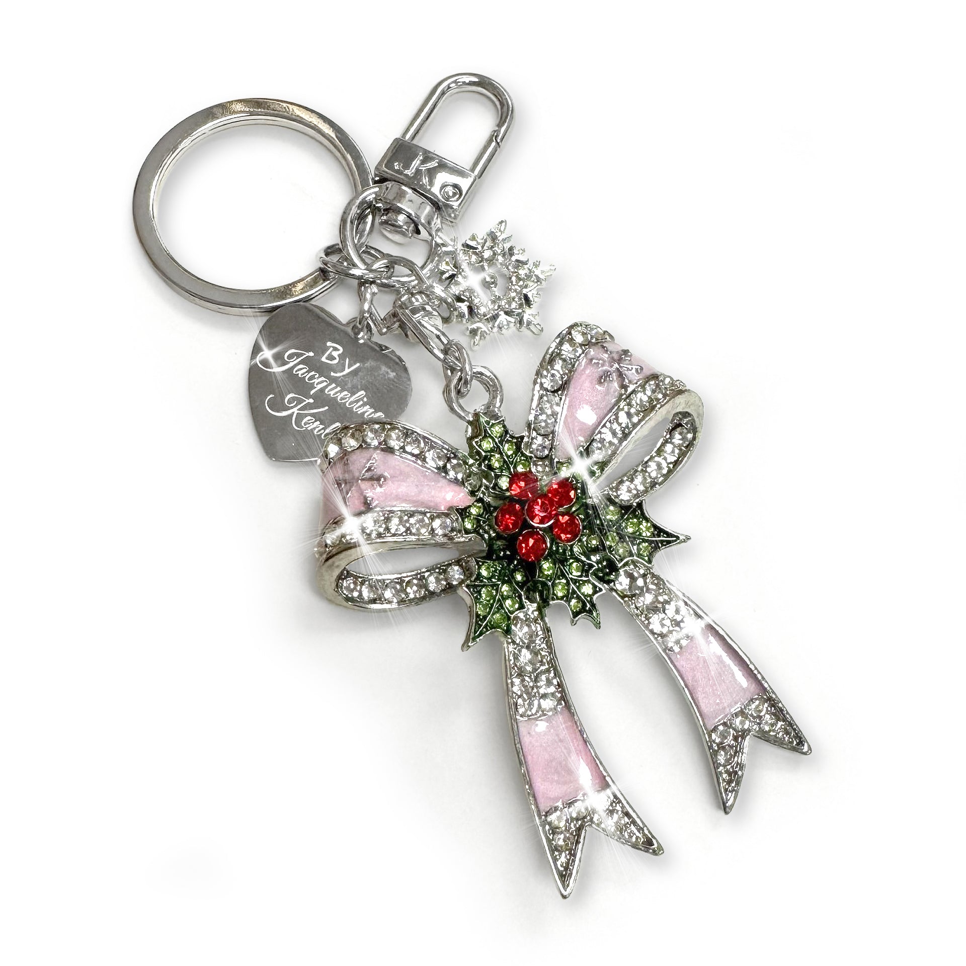 Silver Christmas bow purse charm/keychain in silver with pink enamel, clear, green and red rhinestone details with a silver heart shaped branded Jacqueline Kent tag