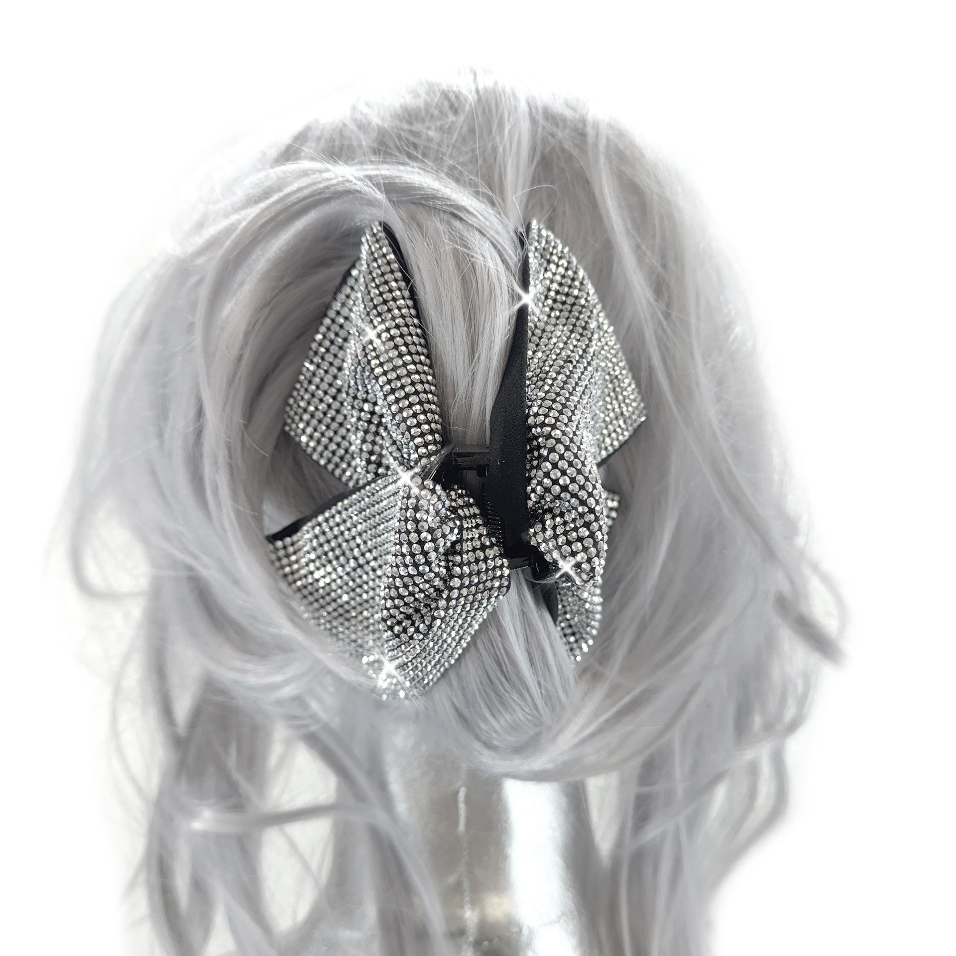 Silver rhinestone bow hair clip on a mannequin head with gray hair
