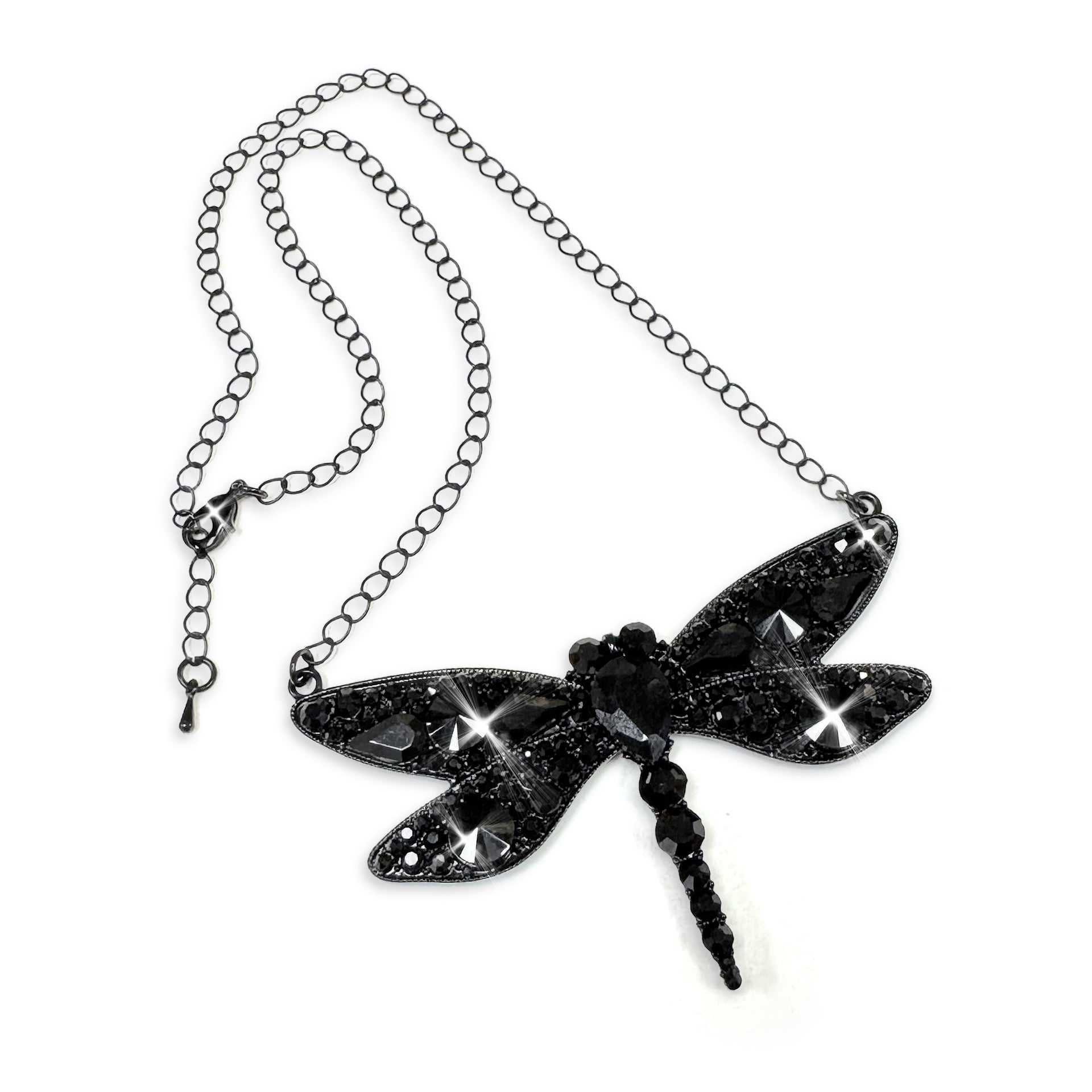 Black glittery dragonfly pendant on a chain against a white background
