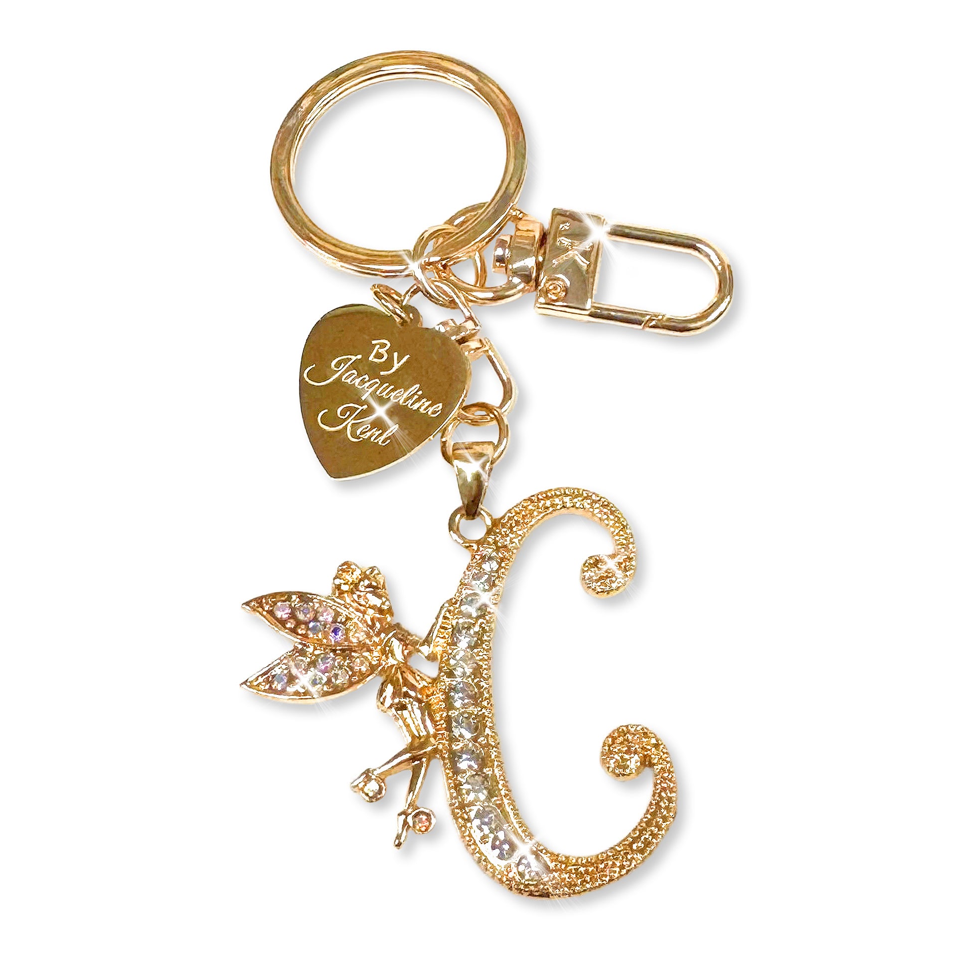 Gold and crystal embellished keychain with decorative letter 'C' and heart-shaped Jacqueline Kent branded tag on a white background
