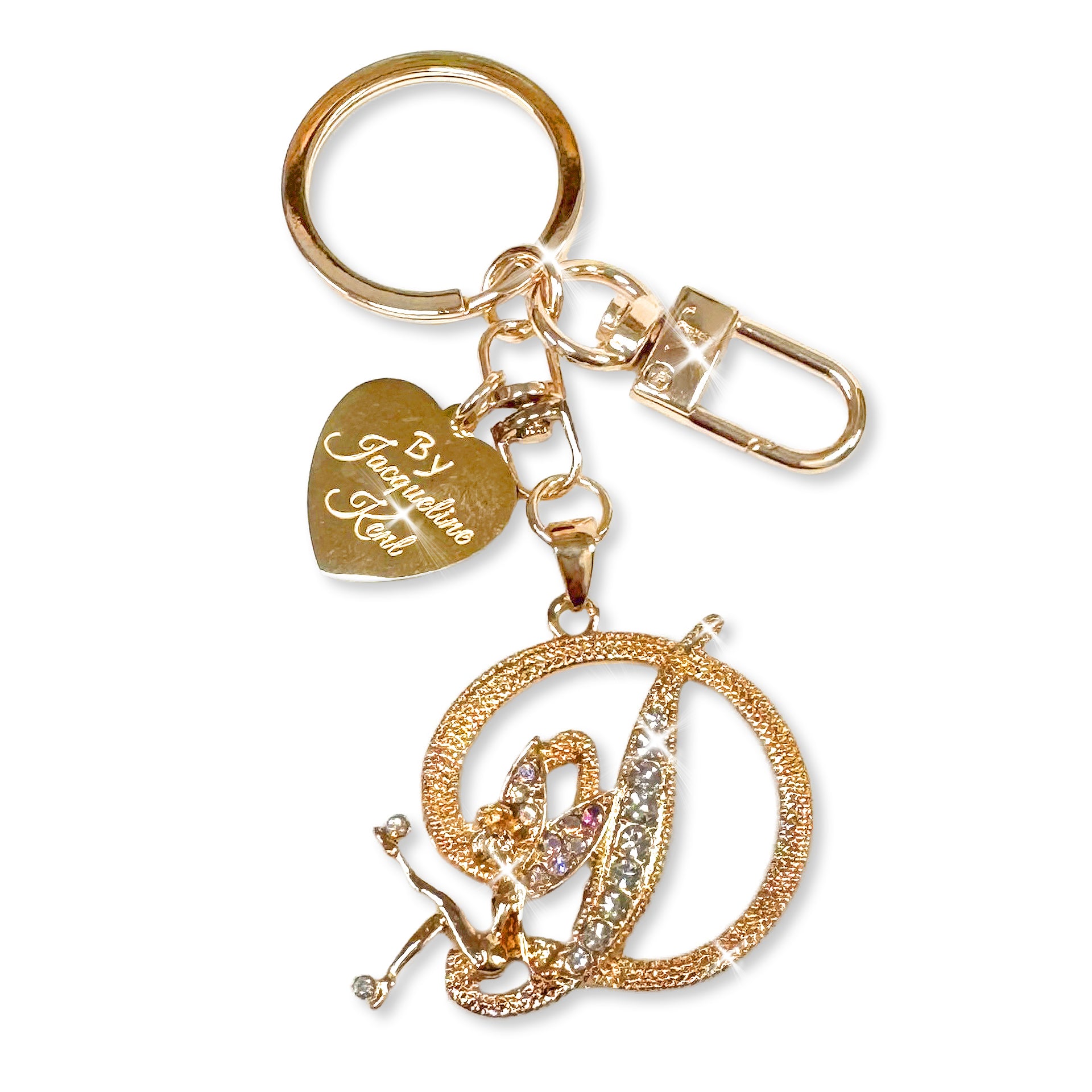 Gold and crystal embellished keychain with decorative letter 'D' and heart-shaped Jacqueline Kent branded tag on a white background