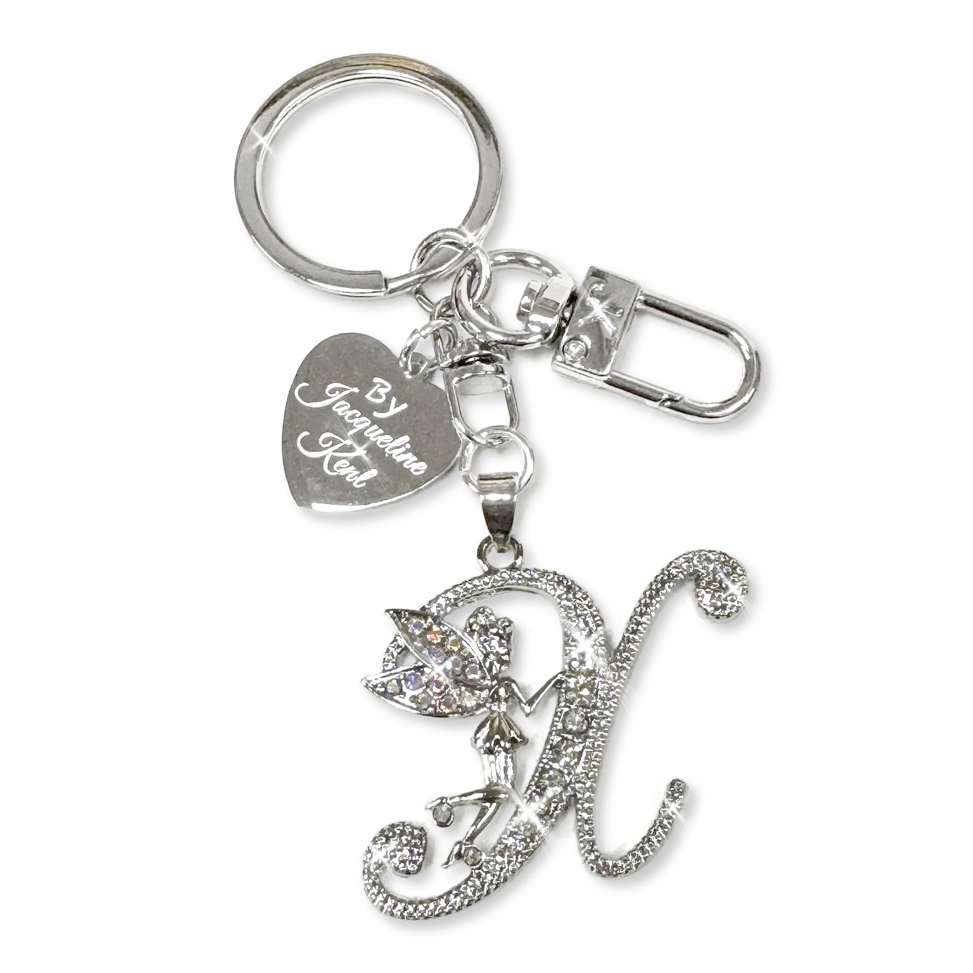 Silver and crystal embellished keychain with decorative letter 'X' and heart-shaped Jacqueline Kent branded tag on a white background