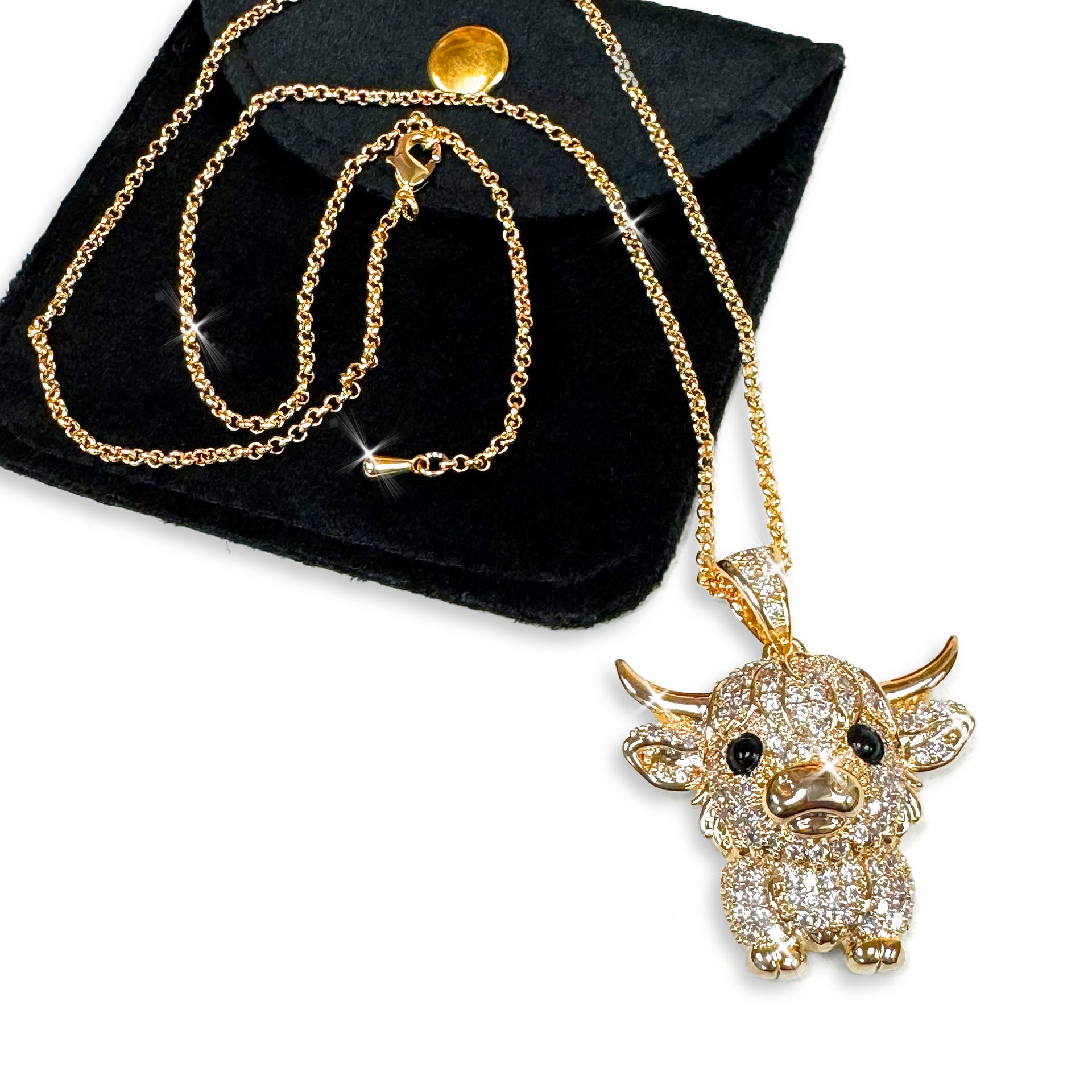 Detailed gold cow pendant necklace embellished with clear crystal rhinestones on a black background