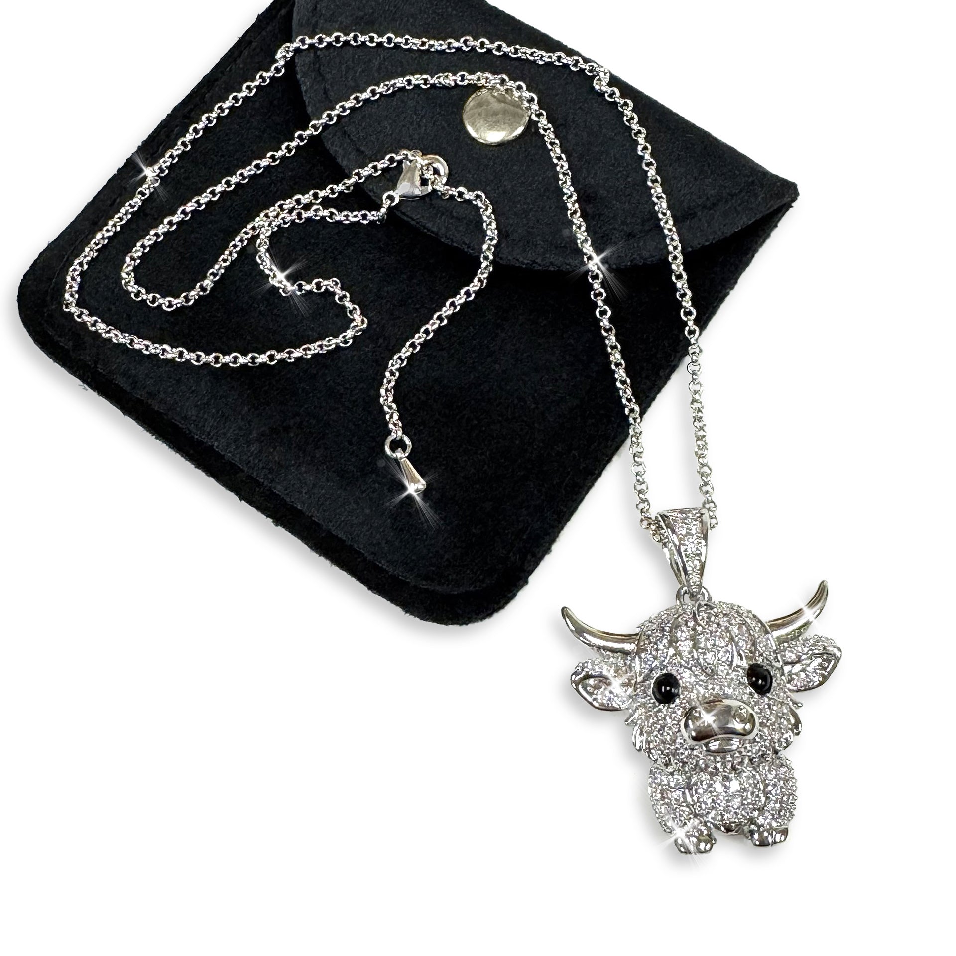 Detailed silver cow pendant necklace embellished with clear crystal rhinestones on a black background