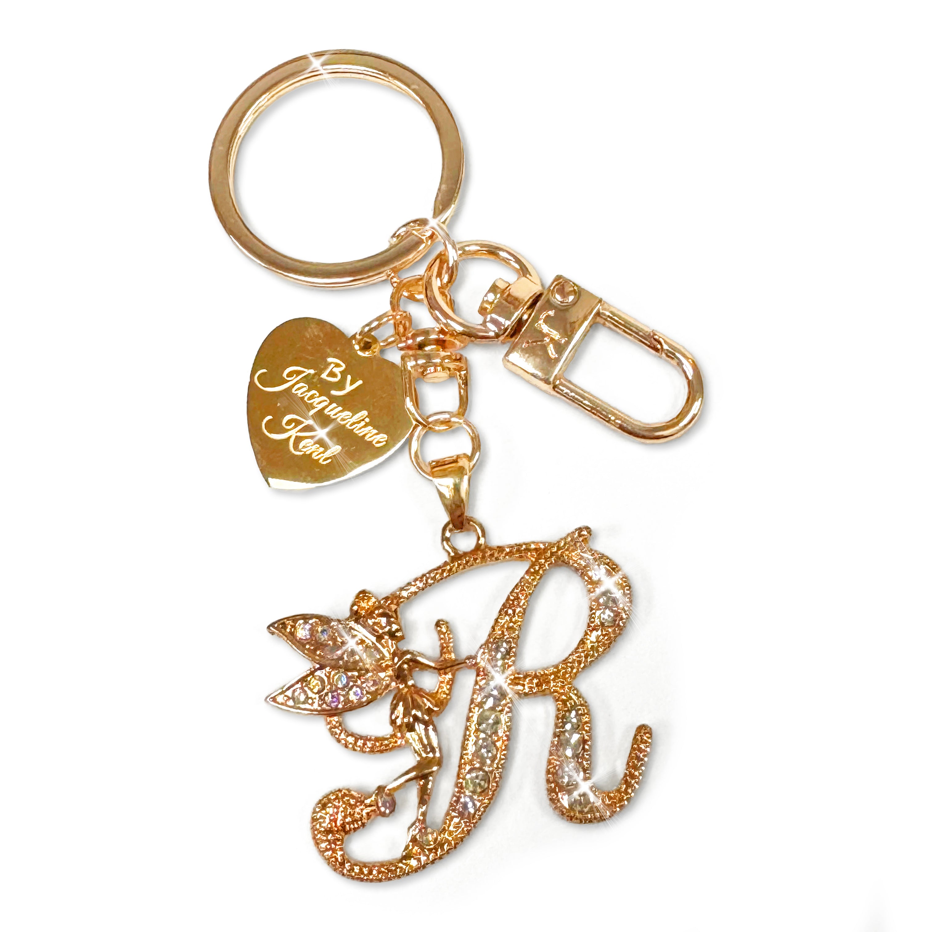 Gold and crystal embellished keychain with decorative letter 'R' and heart-shaped Jacqueline Kent branded tag on a white background