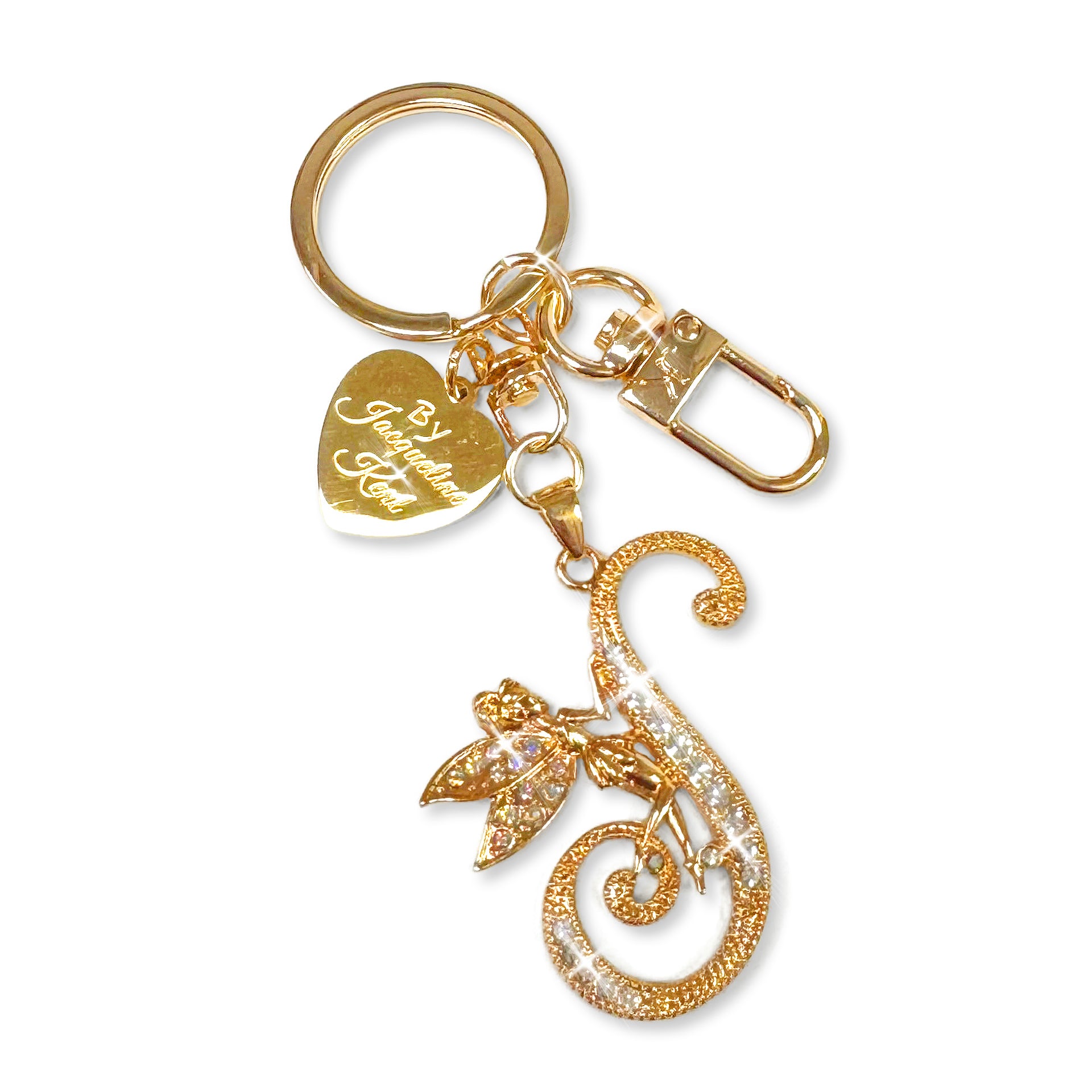 Gold and crystal embellished keychain with decorative letter 'S' and heart-shaped Jacqueline Kent branded tag on a white background
