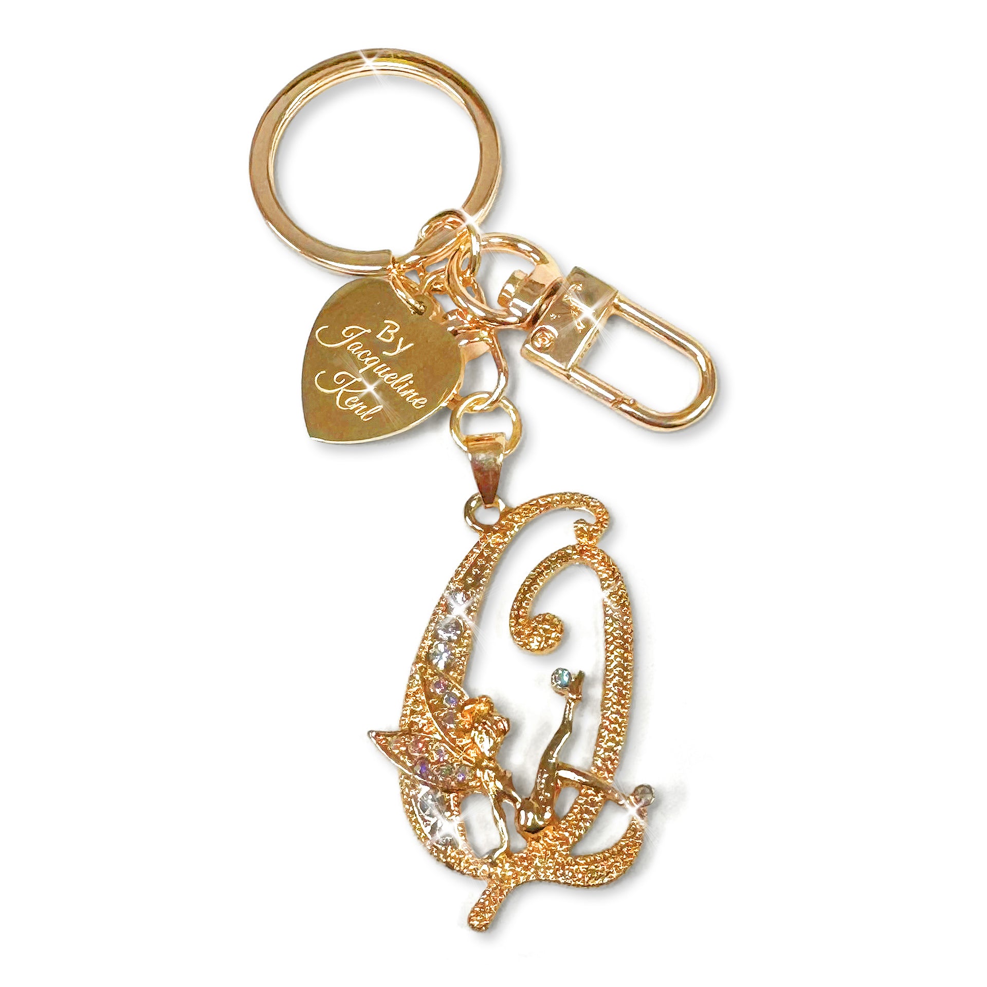 Gold and crystal embellished keychain with decorative letter 'Q' and heart-shaped Jacqueline Kent branded tag on a white background