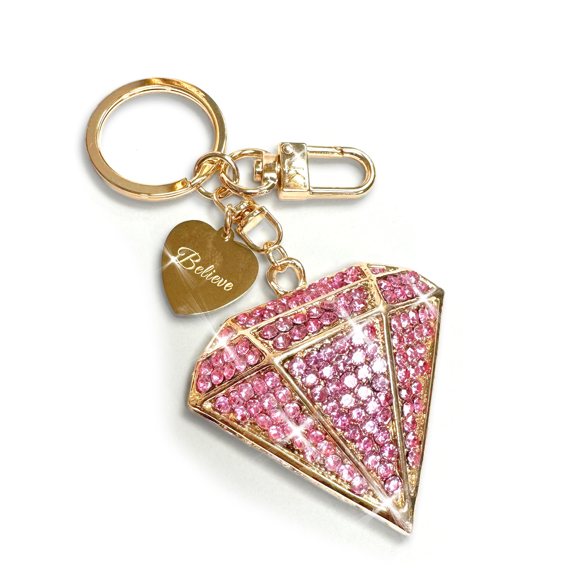 Diamond purse charm/keychain in gold with pink rhinestones and 'I Believe' heart charm on a white background