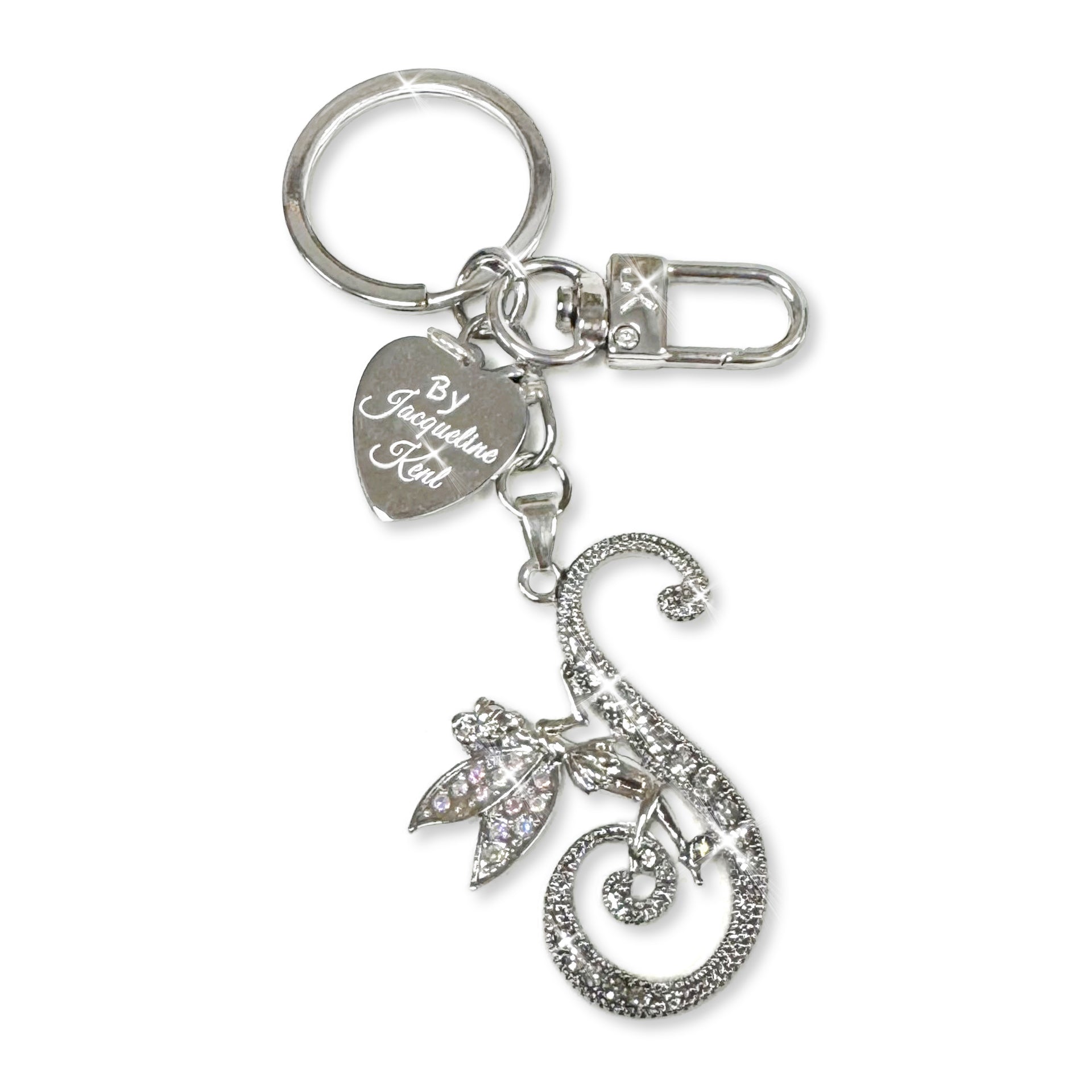 Silver and crystal embellished keychain with decorative letter 'S' and heart-shaped Jacqueline Kent branded tag on a white background