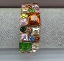 Multicolored crystal ring on a gray background