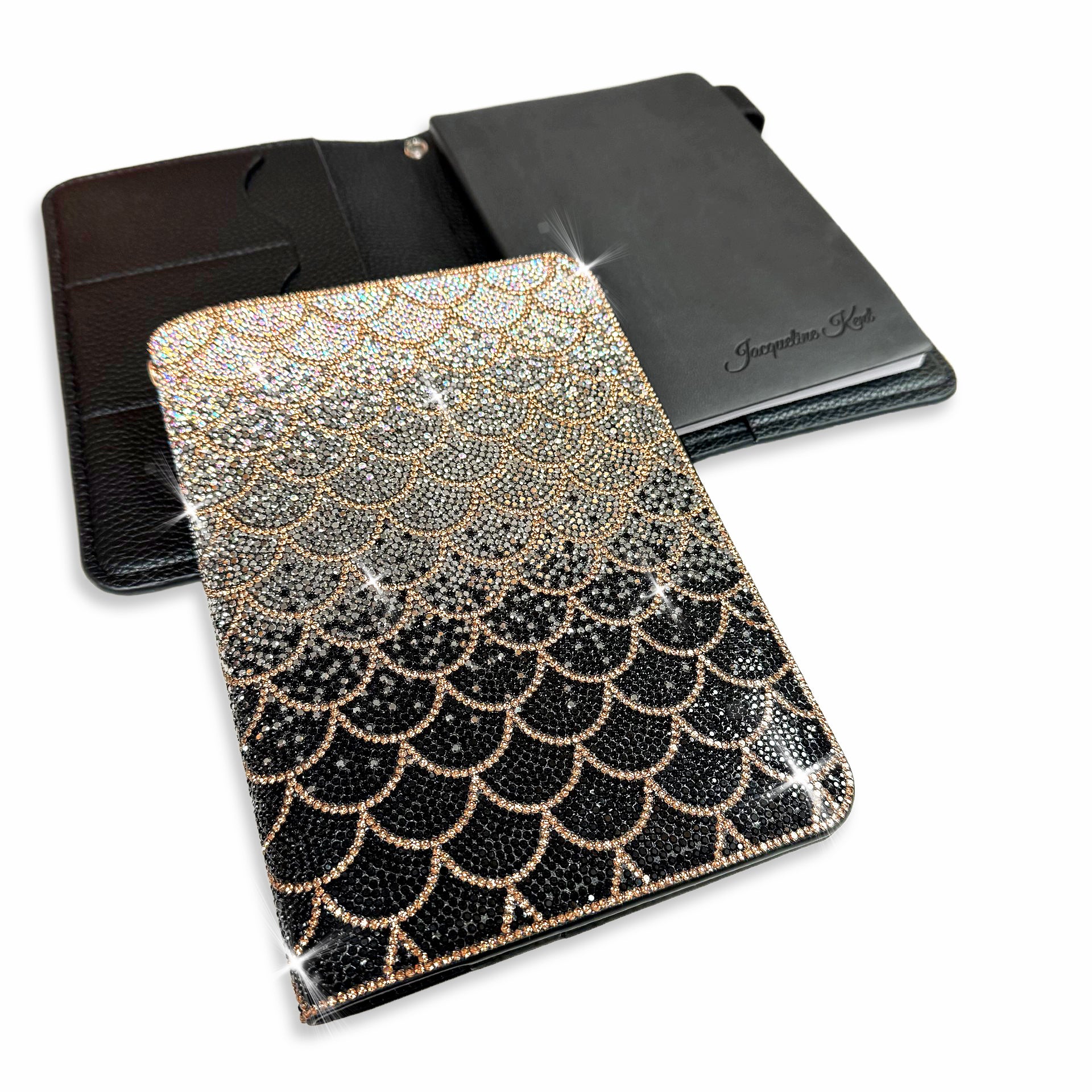 Decorative mermaid scale patterned notebook with a black to silver ombre with gold accents on a white background