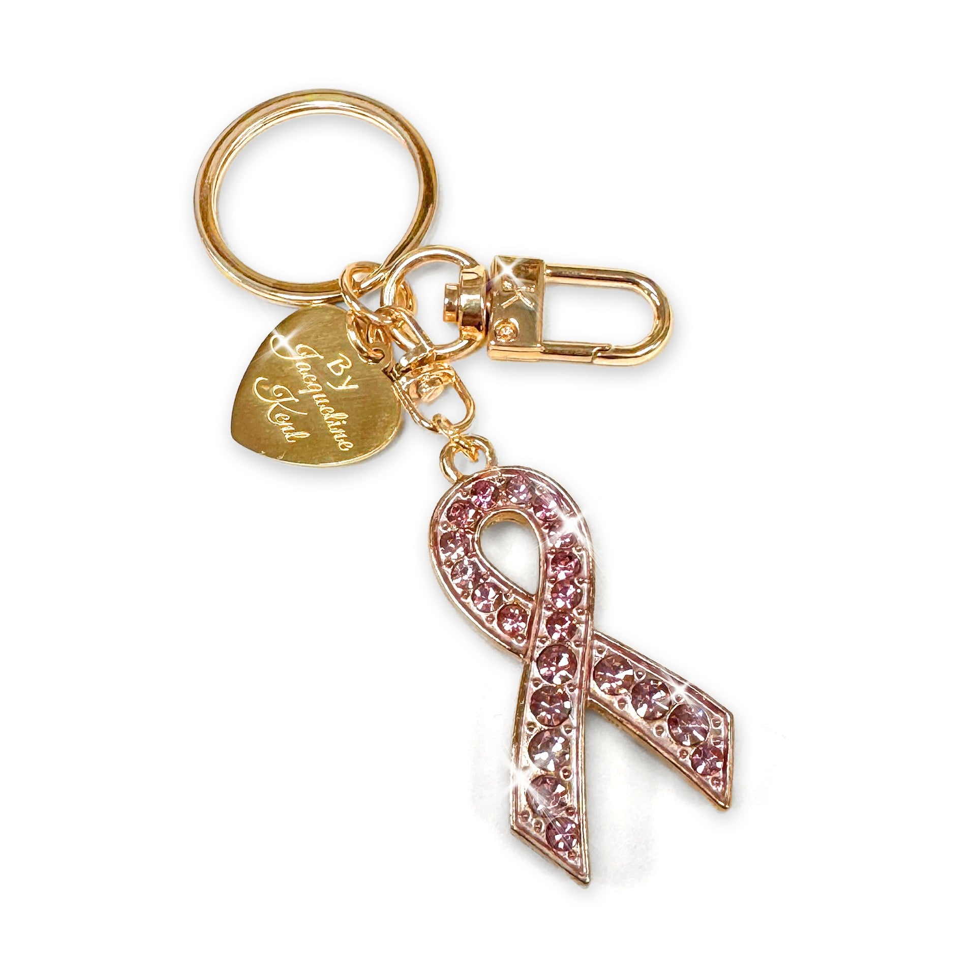 Gold purse charm/keychain with pink rhinestone ribbon charm on a white background